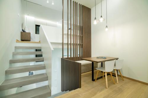 a dining room with a table and a staircase at GM exclusive Luxury Suites & SPA in Sitia