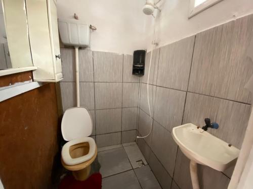 a small bathroom with a toilet and a sink at Itajai Quartos e Suites in Itajaí