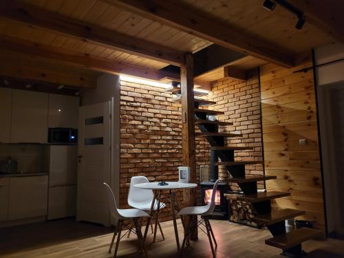 a room with a table and chairs and a brick wall at Domek na Szczycie u Basi in Udryń