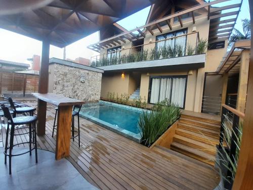 a balcony with a swimming pool and a house at Pousada Kirana in Praia do Rosa