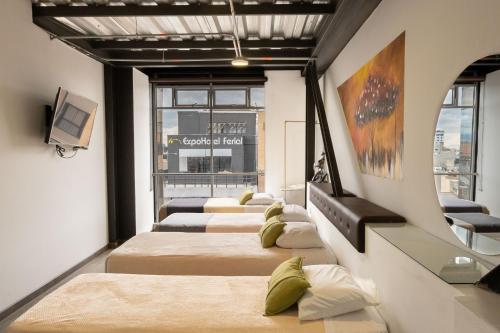 four beds lined up in a row in a room at Hotel Wess in Bogotá