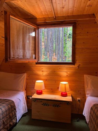 a bedroom with two beds and two lamps on a table at Chalet Natura Sport&Relax in Cavaliere