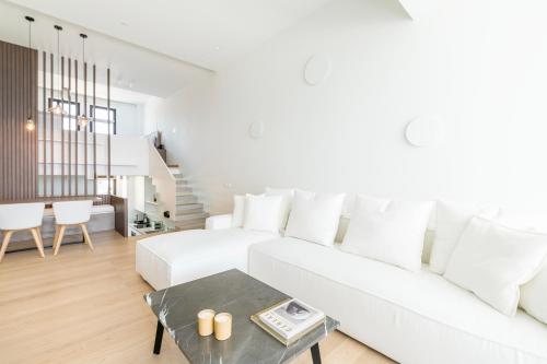 a white living room with a white couch and a table at GM exclusive Luxury Suites & SPA in Sitia
