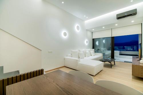 a living room with a white couch and a table at GM exclusive Luxury Suites & SPA in Sitia