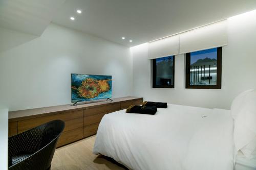 a bedroom with a large bed and two windows at GM exclusive Luxury Suites & SPA in Sitia