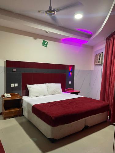 a bedroom with a large bed with a red headboard at Saeed Hotel in Dubai