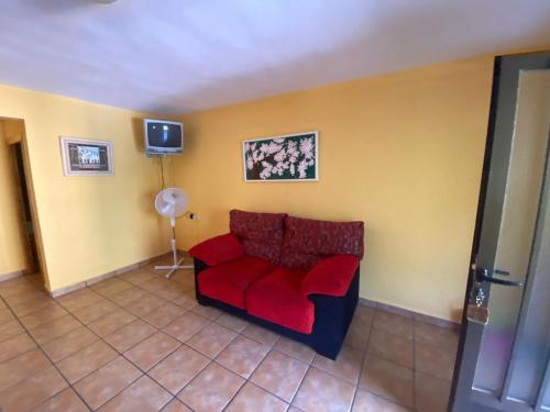 een woonkamer met een rode bank en een tv bij CASA NICOLAS in Molinicos