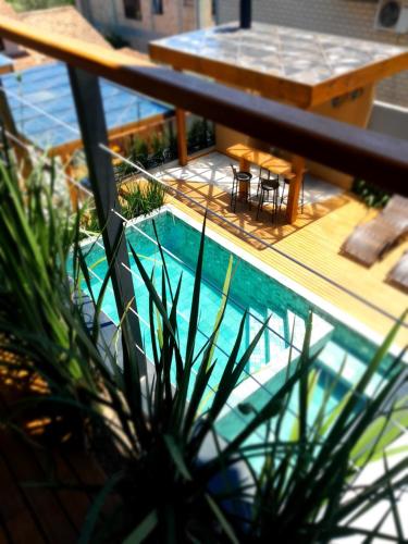 a house with a swimming pool on a balcony at Pousada Kirana in Praia do Rosa