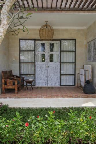 an outdoor patio with a door and a table at Mangga Wangga Living in Uluwatu