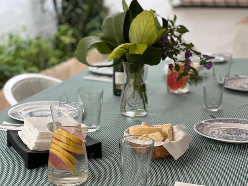 a green table with plates and glasses and a vase of flowers at Villa Remedios in Torremolinos