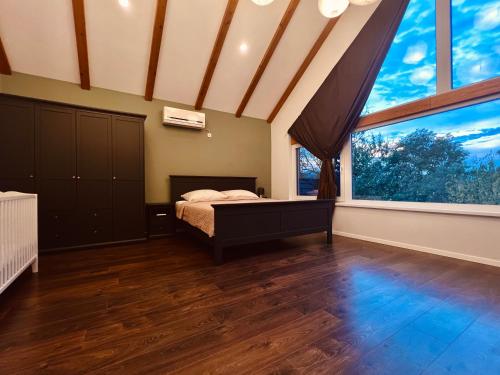 a bedroom with a bed and a large window at House DIKA- sauna & jacuzzi in Otočac