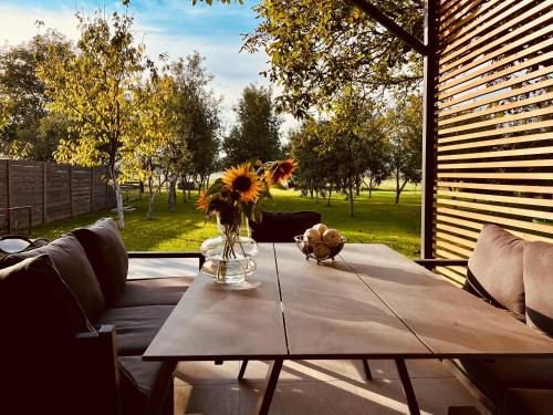 a table with a vase of flowers on top of it at House DIKA- sauna & jacuzzi in Otočac