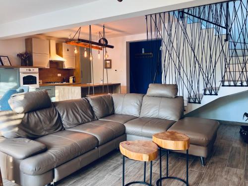 a living room with a leather couch and two tables at House DIKA- sauna & jacuzzi in Otočac
