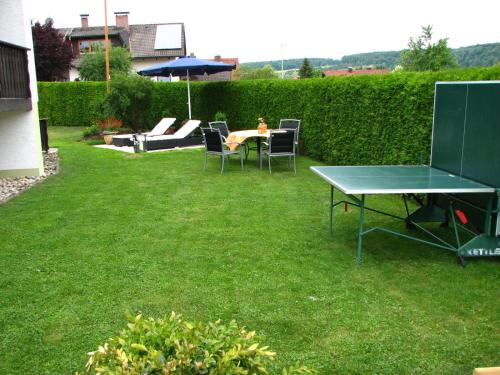 een tafeltennistafel en stoelen in de tuin bij Gegg's Ferienwohnung II in Dollnstein