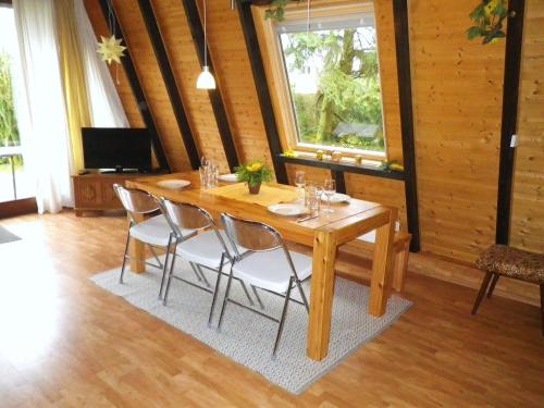 uma sala de jantar com uma mesa de madeira e cadeiras em Ferienhaus-Freilingen em Blankenheim