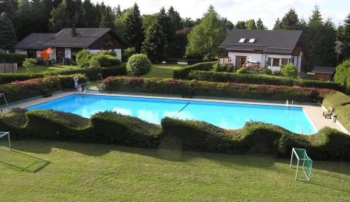 uma grande piscina azul em frente a uma casa em Ferienhaus-Freilingen em Blankenheim