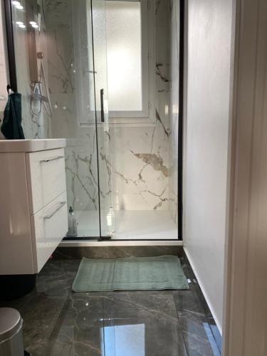 a bathroom with a shower with a glass door at Cosy home à 20min de paris et orly, Parking gratuit in Antony