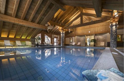 - une grande piscine dans un bâtiment doté de plafonds en bois dans l'établissement Résidence les Alpages - Appartement Boule de neige - 3 pièces 6 personnes, à Champagny-en-Vanoise