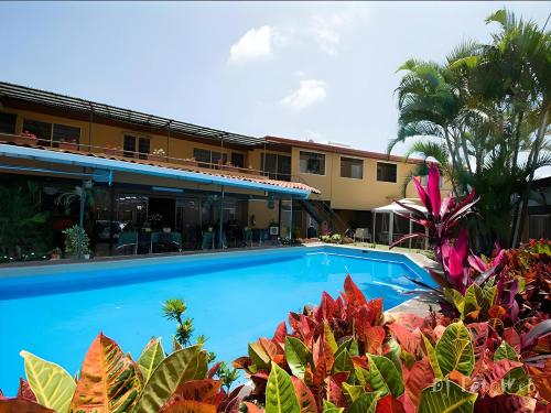 a swimming pool in front of a hotel at Hotel Puerta del Sol - San Jose Airport in San José