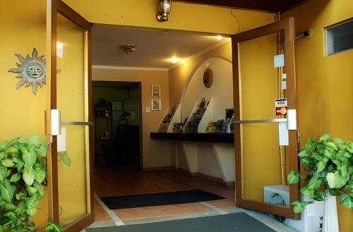 an open door into a room with yellow walls at Hotel Puerta del Sol - San Jose Airport in San José