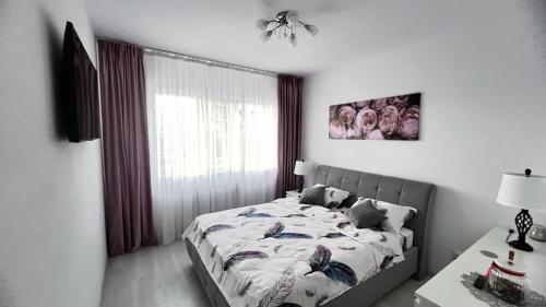 - une chambre avec un lit, une table et une fenêtre dans l'établissement ONE Apartment Militari, à Bucarest