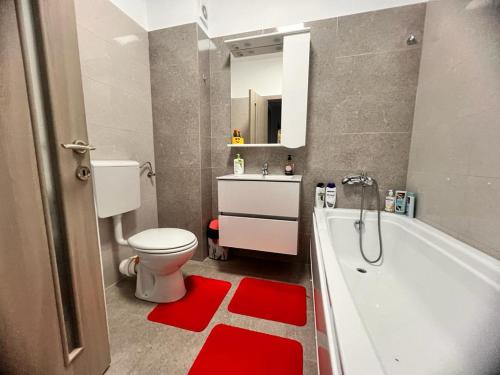 uma casa de banho com um WC branco e uma banheira em ONE Apartment Militari em Bucareste