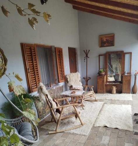 a living room with a table and chairs and windows at Apartments Bakine Čarolije in Karanac