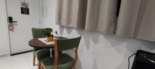 uma pequena mesa e duas cadeiras num quarto em La Home House1 - Apto Studio Confortável em SJP - 10 minutos Aeroporto - Curitiba em São José dos Pinhais