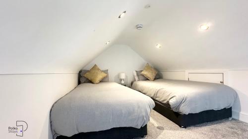 two beds in a attic bedroom with white walls at The Stables, Chester - Luxury Apartments by PolkaStays in Chester