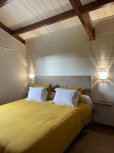 a bedroom with a bed with two pillows and two lights at Austral House-chalet sud sauvage in Saint-Joseph