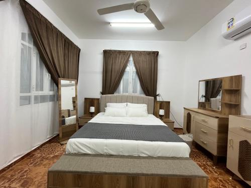 1 dormitorio con 1 cama grande y TV en Relaxation Oasis, en Al Ḩamrāʼ