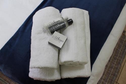 une pile de serviettes blanches avec une brosse à dents sur elles dans l'établissement Sunny Stay, à Groblersdal