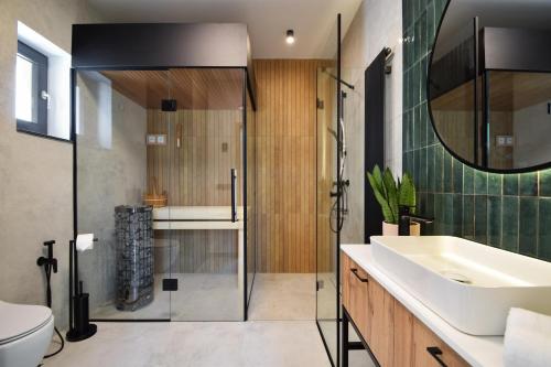 a bathroom with a sink and a shower and a toilet at Boska Gąska Domki Wypoczynkowe in Gąski
