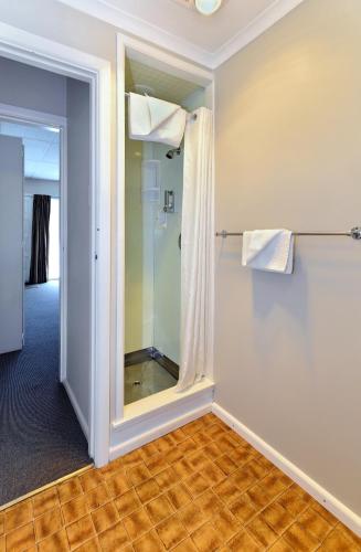 a bathroom with a shower and a mirror at Classique Lodge Motel in Christchurch