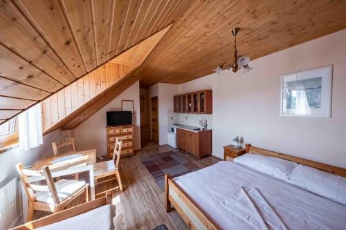 a bedroom with a bed and a desk and a kitchen at Apartmány v Müllerovom dome in Banská Štiavnica