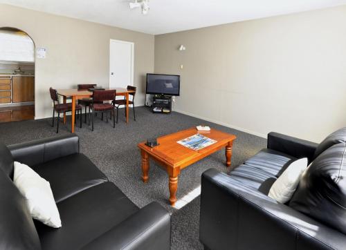 a living room with a couch and a table at Classique Lodge Motel in Christchurch