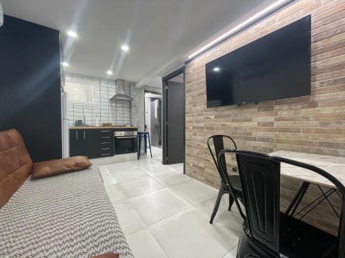 a living room with a large flat screen tv on a brick wall at Benidorm JL 1 y 2 in Benidorm