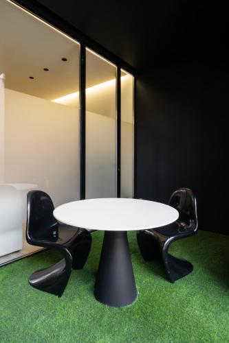 a white table and two black chairs in a room at Cosy Loft's Valencia in Catarroja