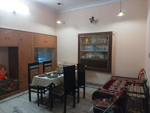 Vanita home stay في أودايبور: غرفة طعام مع طاولة وكراسي في غرفة