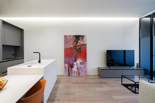 a kitchen with a white counter and a living room at Cosy Loft's Valencia in Catarroja