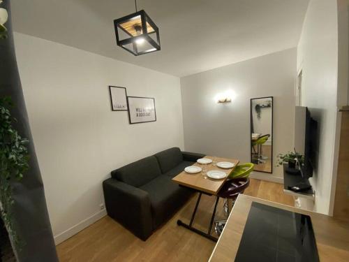 a living room with a couch and a table at Appartement cosy 10 min stade de France in Saint-Denis