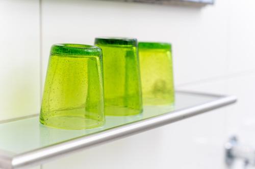 tre vasi di vetro verde seduti su uno scaffale di Art City Studio Kassel 10 a Niestetal