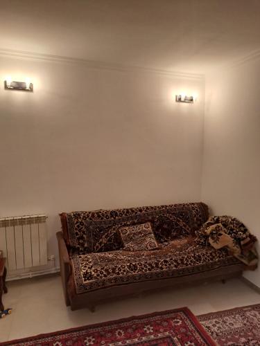 - un canapé dans le salon avec deux lumières sur le mur dans l'établissement Henri house, à Gyumri