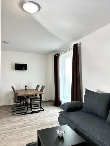 - un salon avec un canapé et une table dans l'établissement Sky Apartments 509, à Plzeň