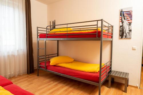 two bunk beds with yellow and red pillows in a room at Art City Studio Kassel 10 in Niestetal