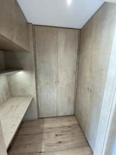 an empty room with wooden cabinets and wood floors at Villa Vue Mer in Lanildut