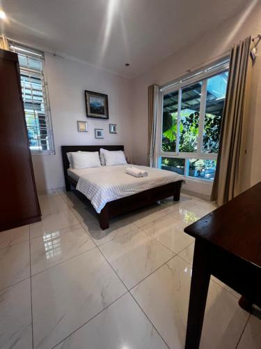 1 dormitorio con cama y ventana grande en NVD12A #notrevilladagonvd for 10pax en Bandung