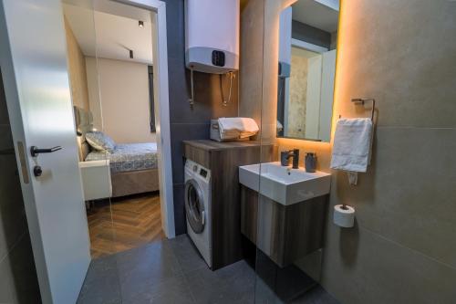 a bathroom with a washing machine and a sink at Villa Diamond One in Banja Luka
