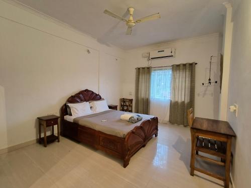 um quarto com uma cama e uma ventoinha de tecto em Apartments close to Thalassa em Siolim