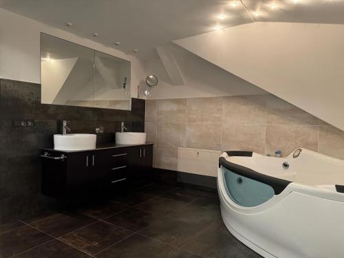 uma casa de banho com uma banheira, um lavatório e uma banheira. em 205 qm "Traumtor" mit Sauna, Whirlpool, Kamin und 3 Terrassen mit Blick in die Böhmisch Sächsische Schweiz em Dresden
